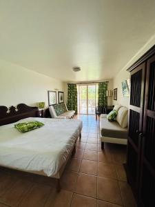a bedroom with a bed and a couch and a chair at Appartement 4 personnes - Sainte-Luce - P&V in Sainte-Luce