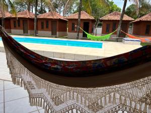 uma rede de descanso em frente a uma piscina em Pousada Nativo's em Nova Almeida