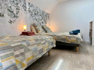 une chambre avec deux lits et un tableau au mur dans l'établissement Charmant Duplex Rénové au Cœur de St Joachim, proche Parc de Brière et Plages - FR-1-306-1222, à Saint-Joachim