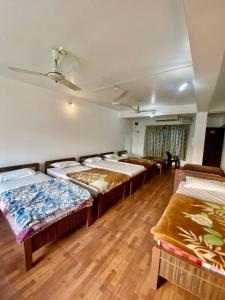 un gruppo di letti in una camera con pavimenti in legno di Hotel Sova's Inn a Birātnagar