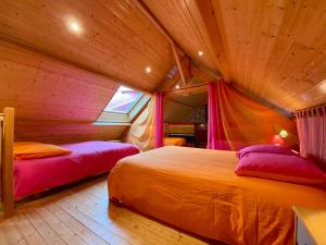 2 Betten in einem Zimmer mit Holzdecken in der Unterkunft Gîte Mésanger, 2 pièces, 6 personnes - FR-1-306-1219 in Mésanger