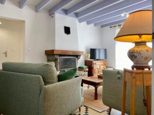salon z 2 krzesłami i kominkiem w obiekcie Maison de vacances spacieuse près de la forêt, avec jardin, cheminée, wifi, et équipements de loisirs. - FR-1-306-1223 w mieście Le Gâvre