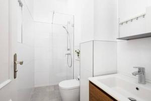 uma casa de banho branca com um WC e um chuveiro em 2bedroom in historic villa near Nymphenburg Palace em Munique