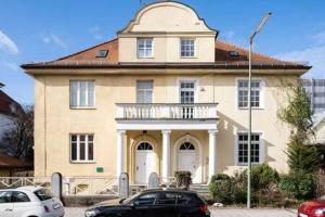 een huis met een auto ervoor geparkeerd bij 2bedroom in historic villa near Nymphenburg Palace in München