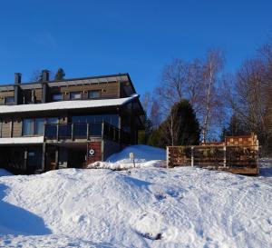 a house with a pile of snow in front of it at Kuikanhovi B Himos in Jämsä