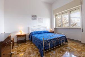 um quarto com uma cama azul e 2 janelas em Casa Vacanze Fernanda em Torre Vado