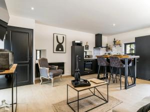 cocina y sala de estar con armarios negros en Gîte Château-Thébaud, 2 pièces, 2 personnes - FR-1-306-1245 en Châteauthébaud