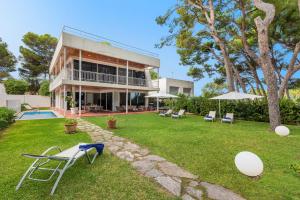 una casa con un patio con sillas y una piscina en Villa Mediterrania I by Esteva Emerald Stay en Alcudia