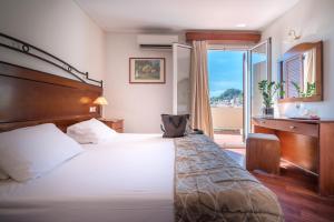 a hotel room with a large bed and a window at Diana Hotel in Zakynthos