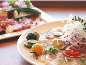 a plate of food with vegetables on a table at The BREAKFAST HOTEL MARCHE Ishigaki Island in Ishigaki Island