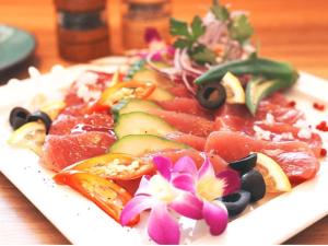 a plate of food with fruits and vegetables on a table at The BREAKFAST HOTEL MARCHE Ishigaki Island in Ishigaki Island