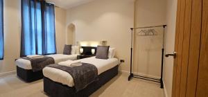 2 łóżka w pokoju hotelowym z niebieskimi zasłonami w obiekcie Modern 2 bedrooms apartment in Town centre w mieście Ipswich