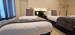 sypialnia z 2 łóżkami z białą pościelą i kominkiem w obiekcie Modern 2 bedrooms apartment in Town centre w mieście Ipswich