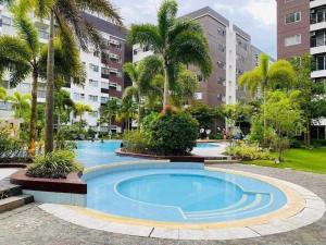 una piscina en un complejo de apartamentos con palmeras en TOWER 3 421 POOL VIEW, en Iloilo City