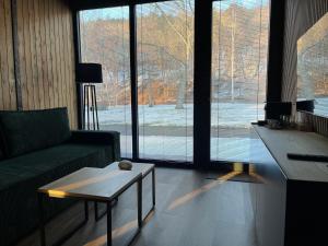 a living room with a couch and a table and large windows at River wellness in Jince