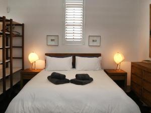 een slaapkamer met een groot wit bed met 2 lampen bij 40 on Longmarket in Stanford