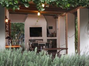 a patio with a table and a television on a house at Lavender’s Blue in Stanford