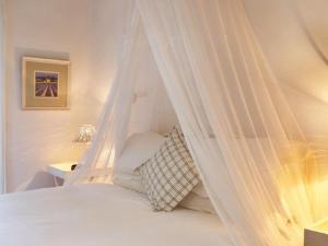 a white bed with a canopy in a bedroom at Lavender’s Blue in Stanford