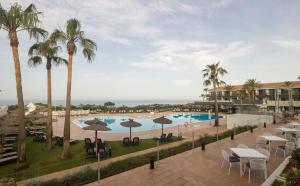 a view of the pool at a resort with tables and umbrellas at Ilunion Calas de Conil in Conil de la Frontera