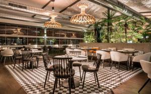 a restaurant with tables and chairs on a checkered floor at Ilunion Calas de Conil in Conil de la Frontera