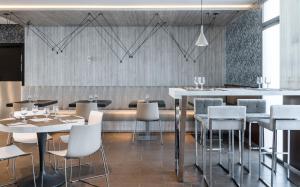 a restaurant with tables and chairs and a bar at Ilunion Calas de Conil in Conil de la Frontera
