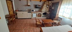 a kitchen with a fireplace and a table and chairs at Apartamentos Casa Rural La Pandera in Jaén