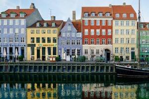 un grupo de edificios junto a un río con un barco en Apartment with Private Balcony in central Copenhagen City, en Copenhague