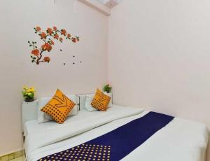 1 dormitorio con 1 cama con almohadas de color naranja y azul en Flagship Stay Inn en Kota