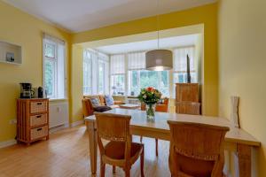 eine Küche mit einem Esstisch und Stühlen in der Unterkunft Haus Friedrichsen 05 in Wyk auf Föhr