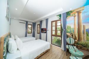 フーコックにあるCybele Sunset Hotel Phu Quocのベッドルーム1室(ベッド2台付)が備わります。壁には絵画が飾られています。