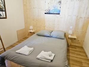- un lit dans une chambre avec 2 serviettes dans l'établissement Jolie maison à Marsanne, à Marsanne