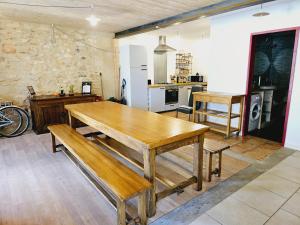 una cocina con mesa de madera y bancos. en Jolie maison à Marsanne, en Marsanne