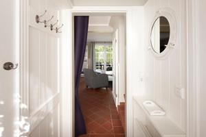 - un couloir avec un miroir et une chaise dans la chambre dans l'établissement Haus Eiderstedt 1, à Wyk auf Föhr