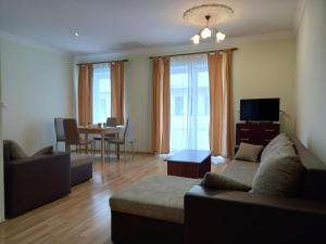 ein Wohnzimmer mit einem Sofa und einem Tisch in der Unterkunft Apartmany Orava in Trenčianske Teplice