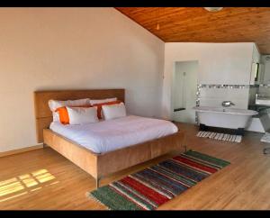 1 dormitorio con cama, bañera y lavamanos en OakTree Guest House, en Sandton