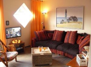 - un salon avec un canapé et une table dans l'établissement Ferienhaus Ambiente, à Harlesiel