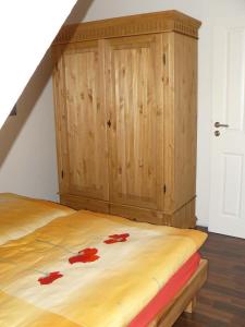 - une chambre avec un lit en bois orné de fleurs rouges dans l'établissement Ferienhaus Ambiente, à Harlesiel