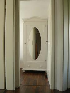 - un couloir avec un miroir dans une chambre blanche dans l'établissement Ferienhaus Ambiente, à Harlesiel