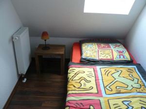 ein kleines Schlafzimmer mit einem Bett und einem Nachttisch in der Unterkunft Ferienhaus Ambiente in Harlesiel
