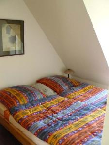 - un lit avec une couverture colorée dans l'établissement Ferienhaus Ambiente, à Harlesiel