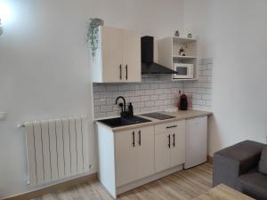 a kitchen with white cabinets and a sink at Apartamento rural "El Albarelo" in Belmonte