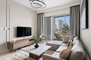 uma sala de estar com um sofá e uma televisão em Silkhaus luxurious 1BDR in new tower with pool & gym no Dubai
