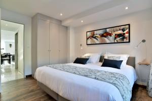 康卡勒L'Ostra 0, appartement haut standing front de mer à Cancale sur le Port de La Houle的卧室里有一张白色的大床，墙上挂着一幅画