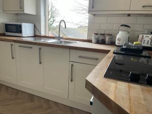 a kitchen with a sink and a stove top oven at Old Hundred View in Tormarton