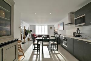 康卡勒L'Ostra 0, appartement haut standing front de mer à Cancale sur le Port de La Houle的厨房里有一张桌子和几把椅子