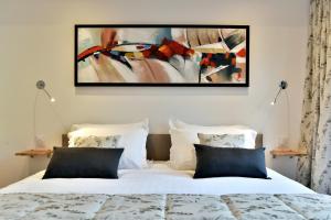 康卡勒L'Ostra 0, appartement haut standing front de mer à Cancale sur le Port de La Houle的卧室里有一张床，墙上挂着一幅画