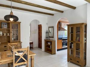 Villa La Maroma - Spacious and quiet family home في ألكاوثين: مطبخ بدولاب خشبي وطاولة