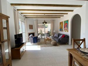 Villa La Maroma - Spacious and quiet family home في ألكاوثين: غرفة معيشة مع أريكة وتلفزيون