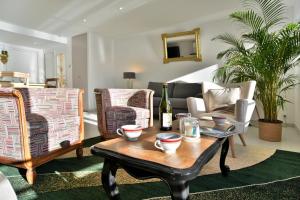 - un salon avec une table, des chaises et un canapé dans l'établissement L Ostra 1, à Cancale
