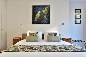 1 dormitorio con 1 cama con una pintura en la pared en L Ostra 1 en Cancale